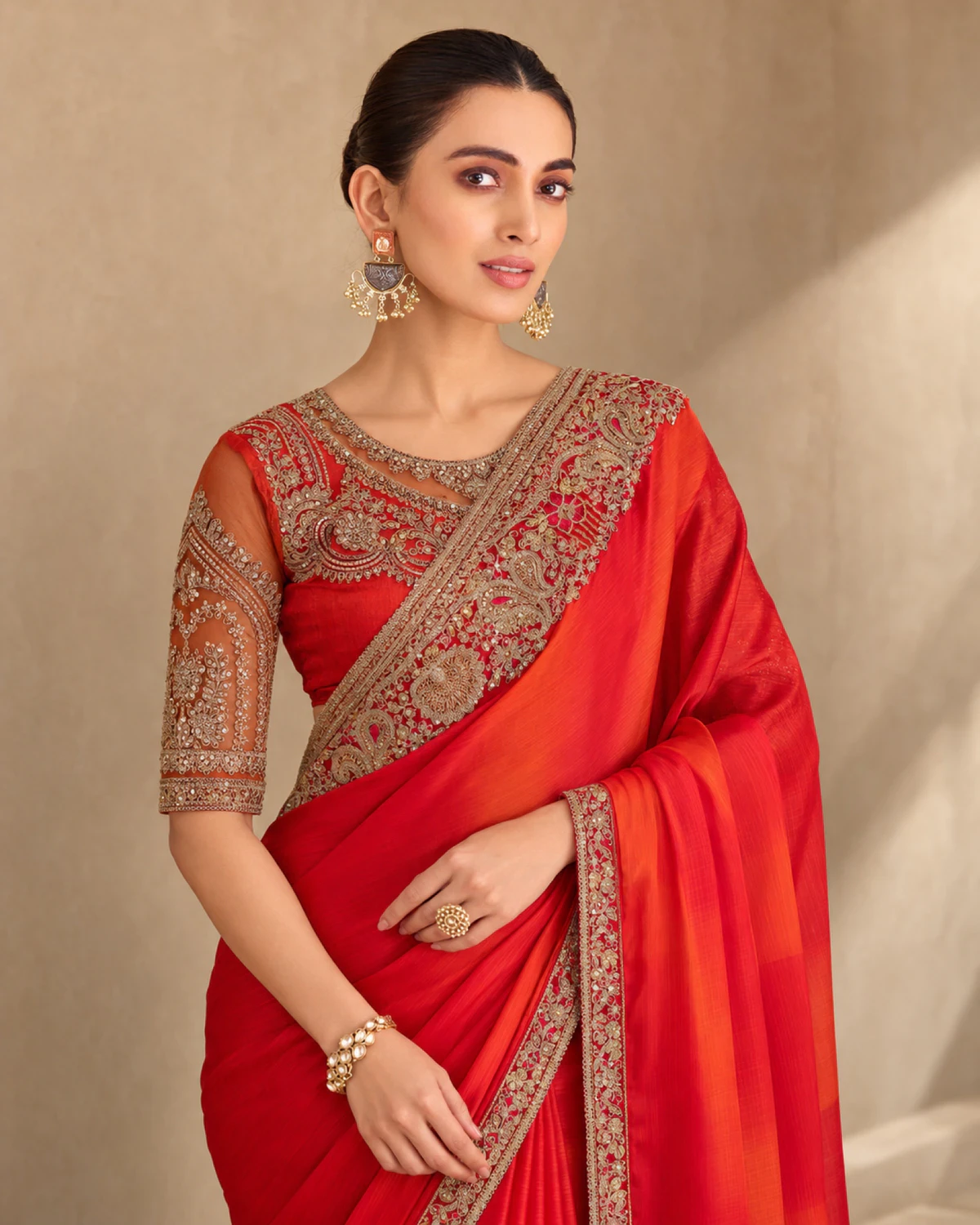Close-up of the red sparkle chiffon saree's embroidered shoulder and the red blouse embroidered in gold