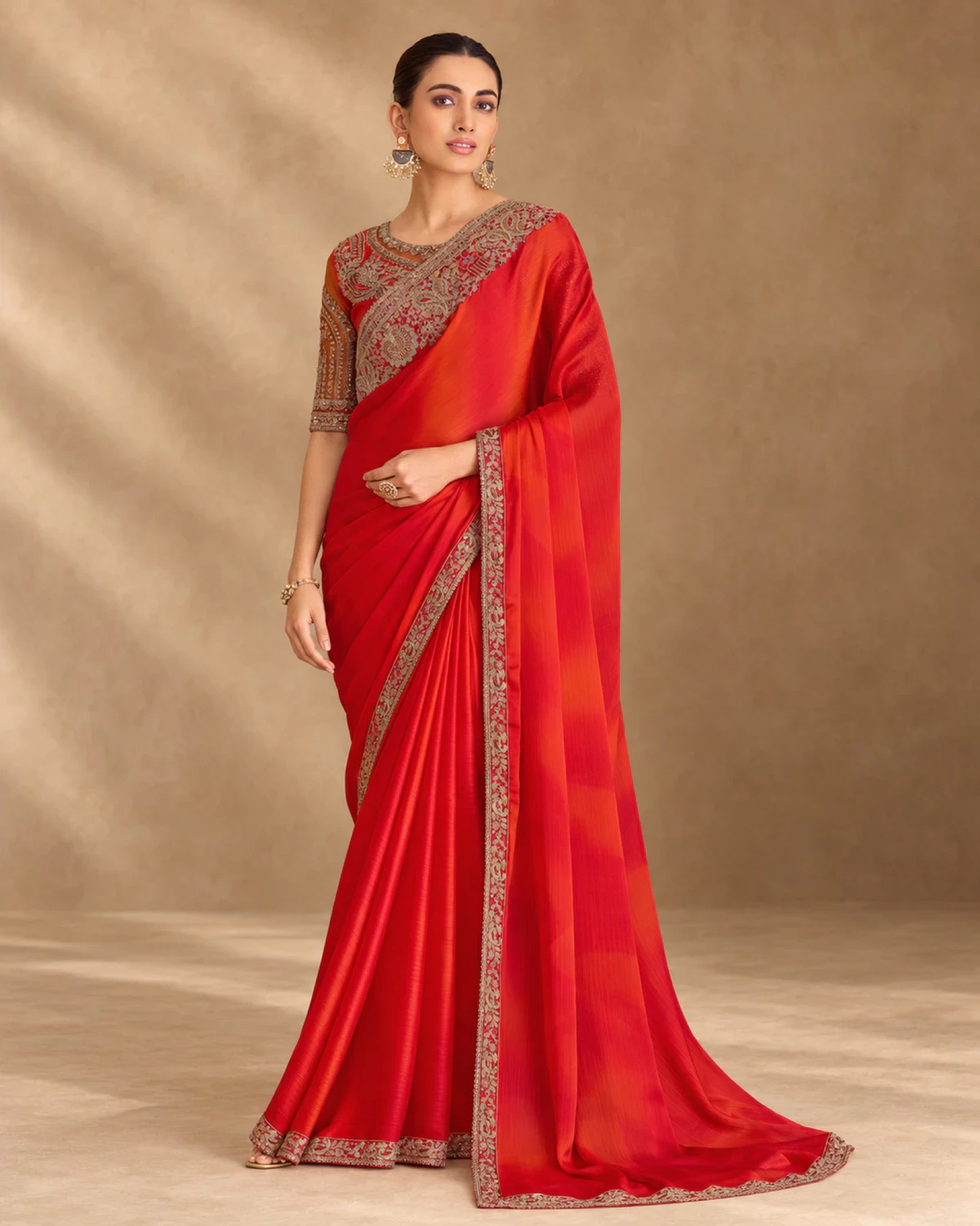 Full-length view of the red shaded sparkle chiffon saree with its gold embroidered border