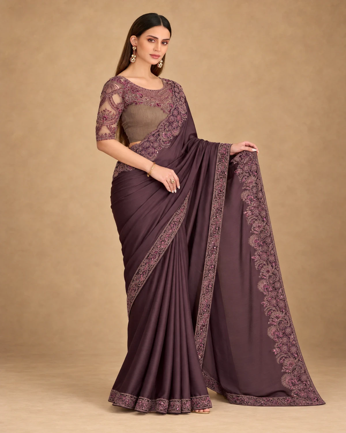 Woman holding out the embroidered pallu of the plum satin chiffon saree