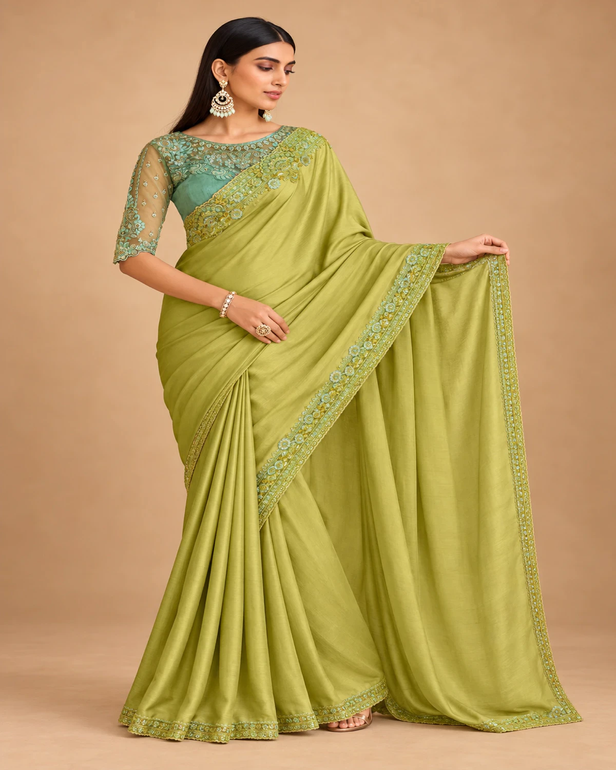 Woman holding out the pallu of the lime green satin chiffon saree