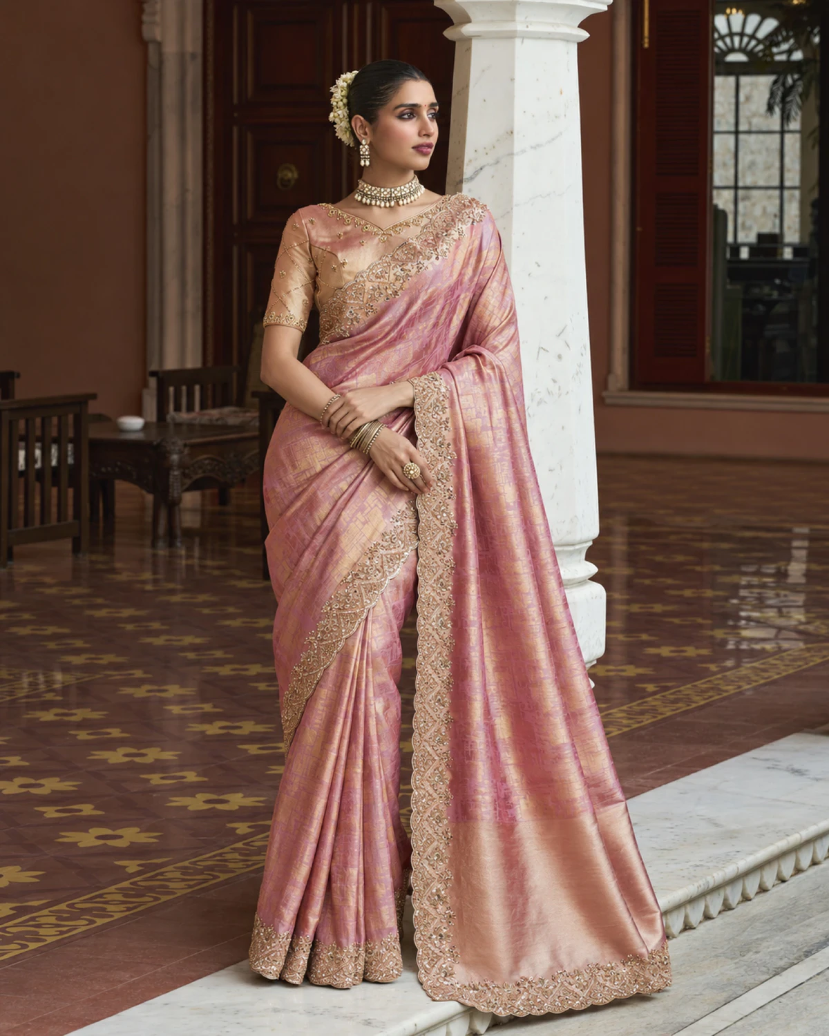 Full-length view of the rose pink soft silk saree with its pallu falling over one arm