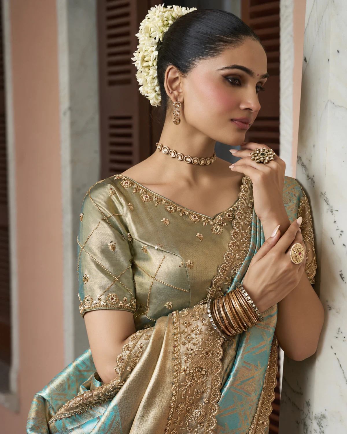 Close-up of the aqua saree's beaded border and the olive-gold blouse with bead work
