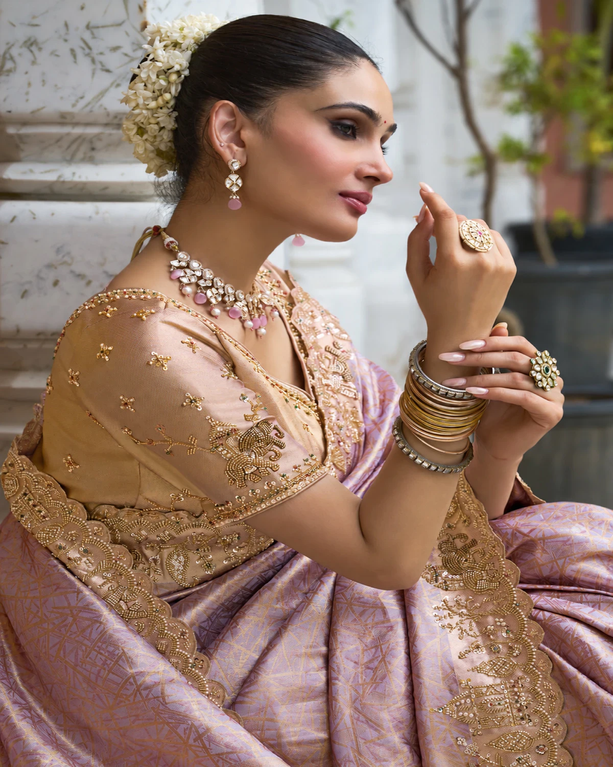 Close-up of a woman in a blush lilac Kanjivaram-style soft silk saree with a beaded border and a peach-gold blouse