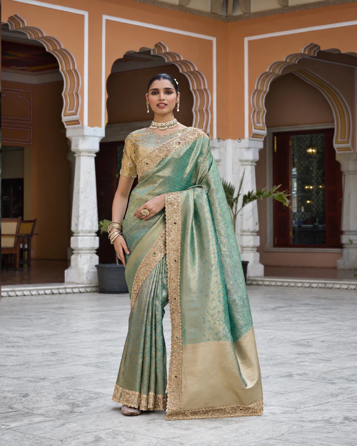 Full-length view of the mint green soft silk saree in an arched courtyard