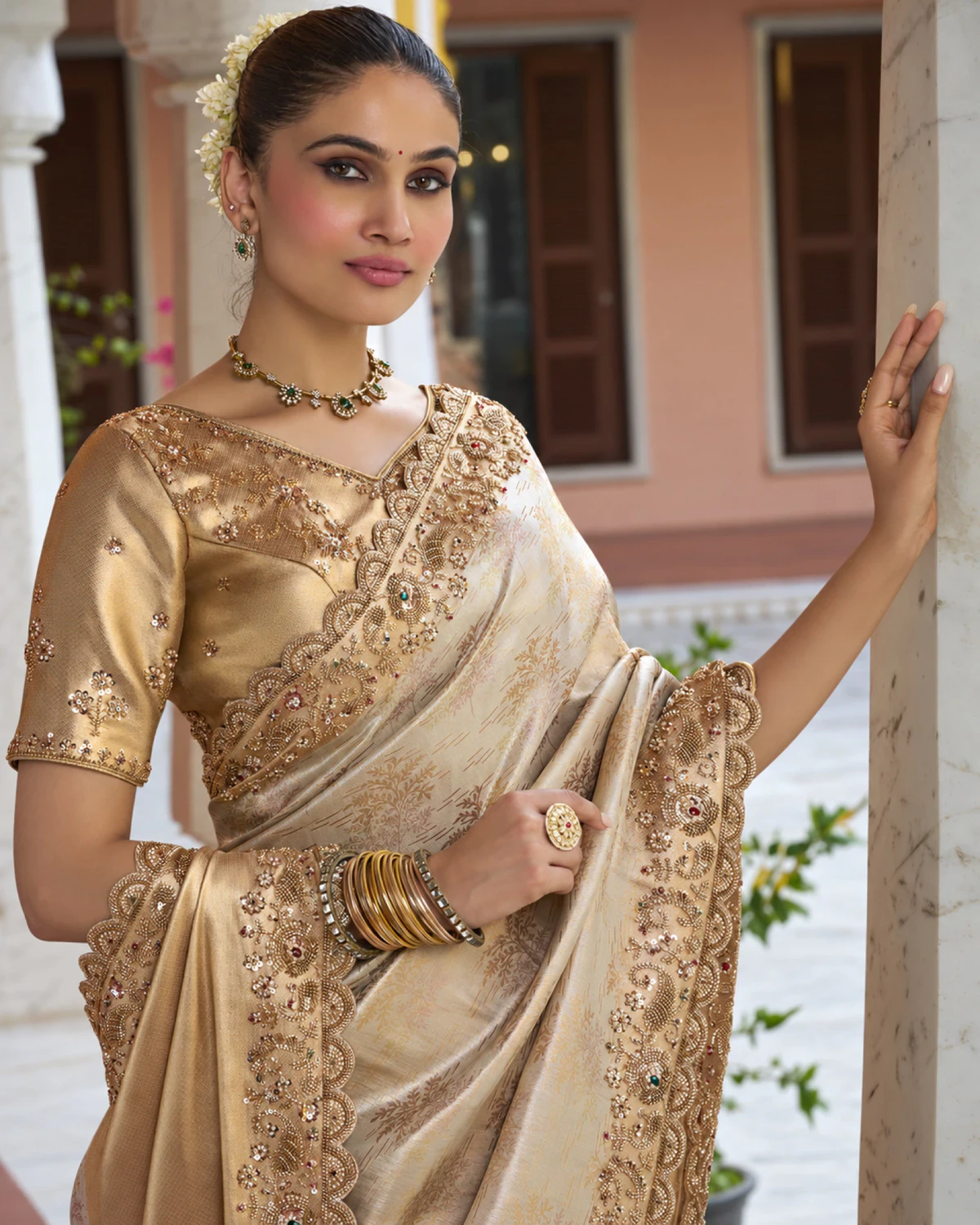 Close-up of a woman in an ivory Kanjivaram-style soft silk saree with a beaded border and a gold blouse
