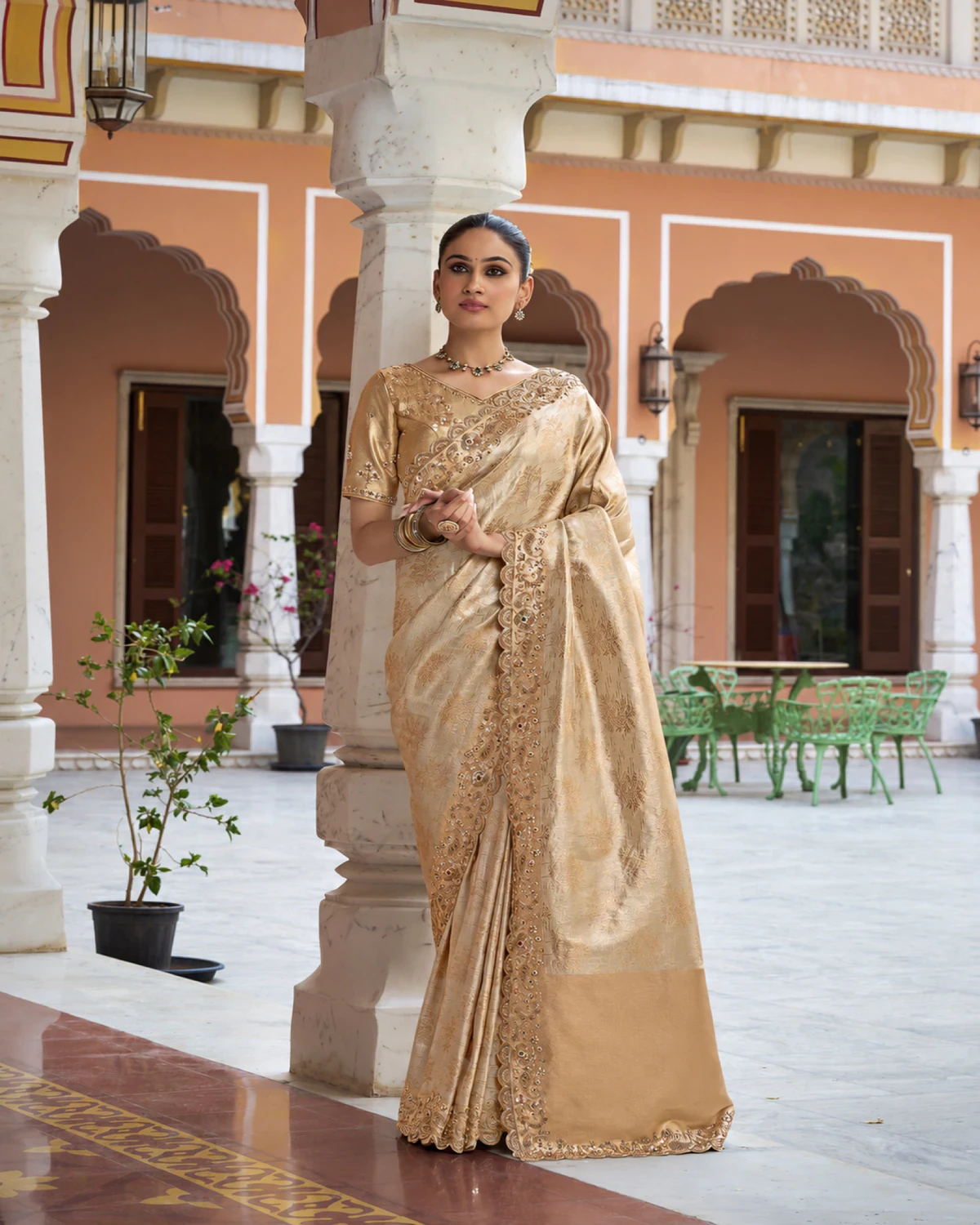 Woman wearing the ivory soft silk saree by a pillar in an arched courtyard